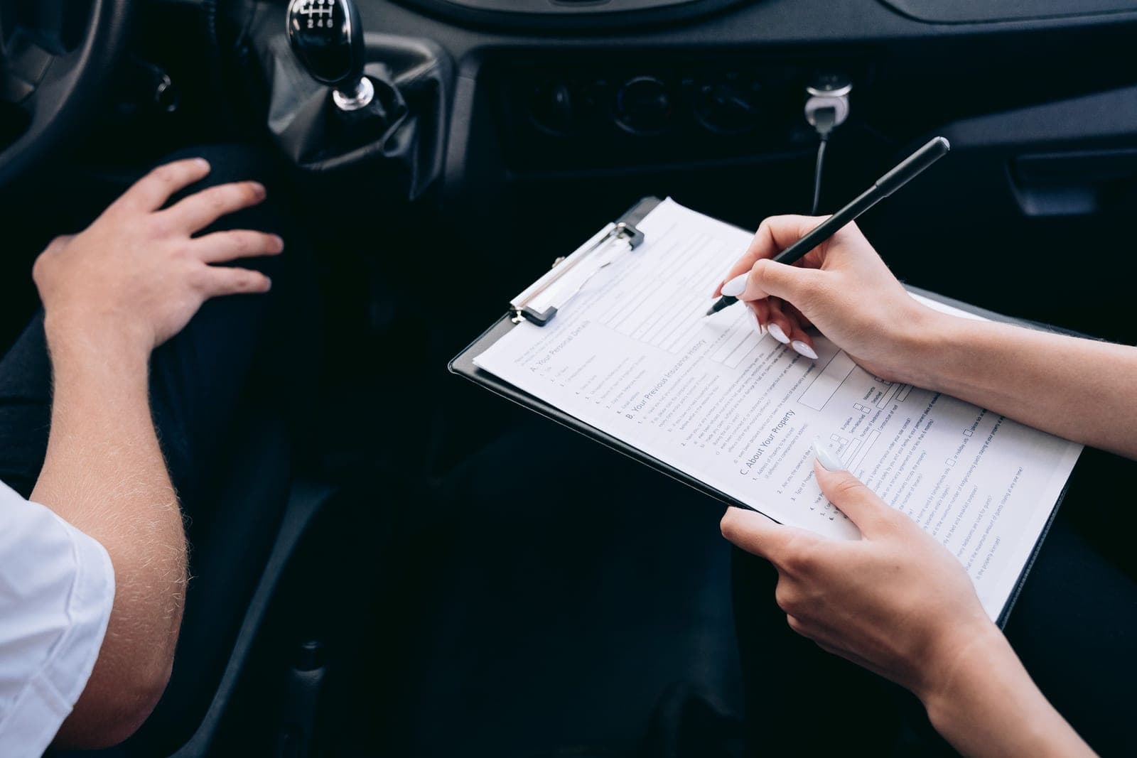 Notes being written on a clipboard inside a vehicle