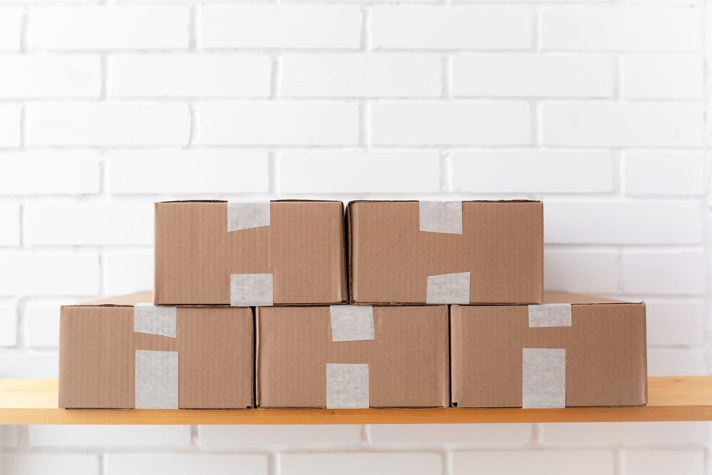 Sealed cardboard parcels stacked on a shelf ready for despatch