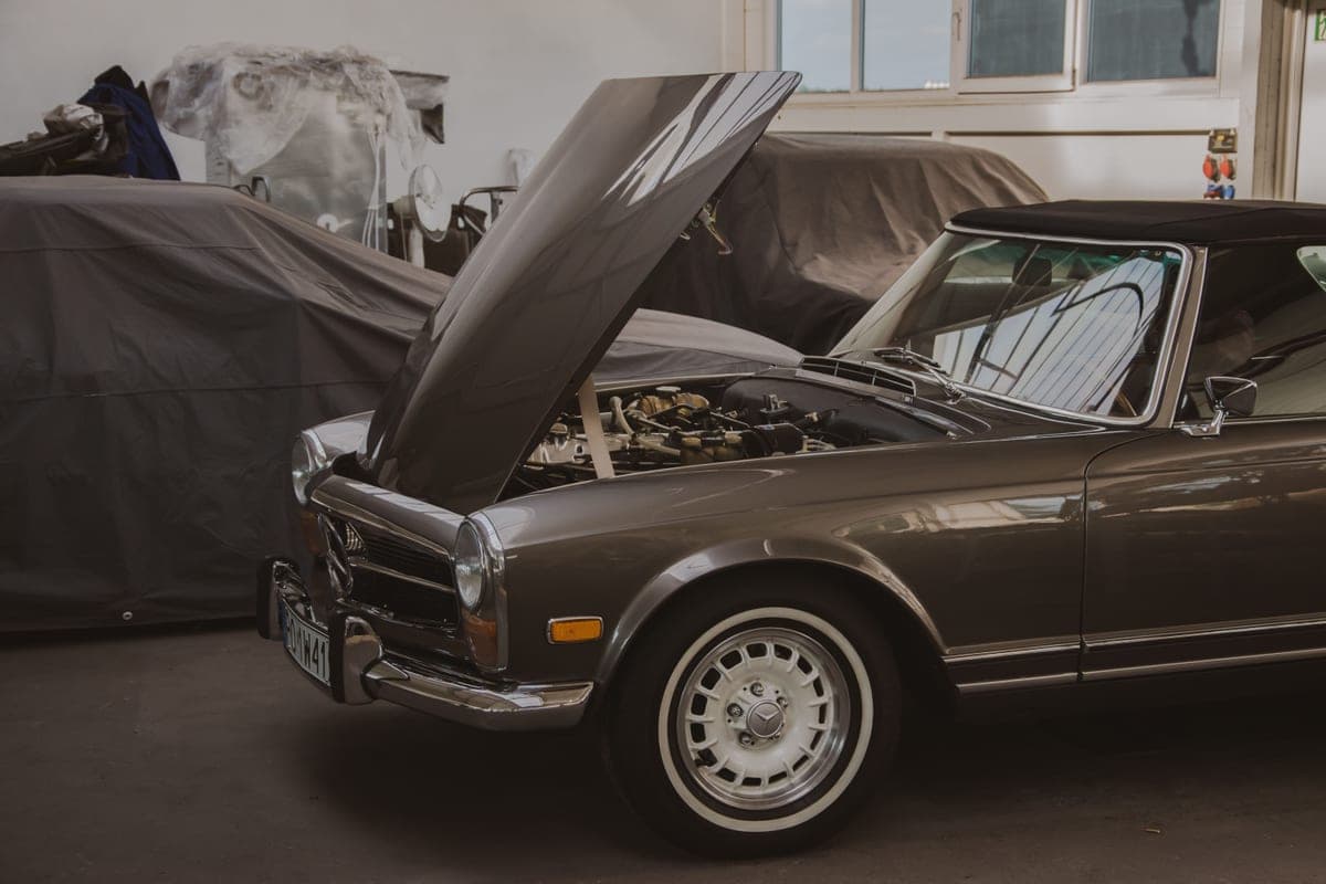 Classic car in a workshop with its bonnet raised