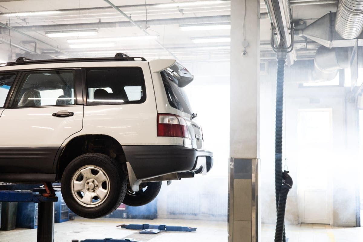 Vehicle raised on a two-post lift in a workshop